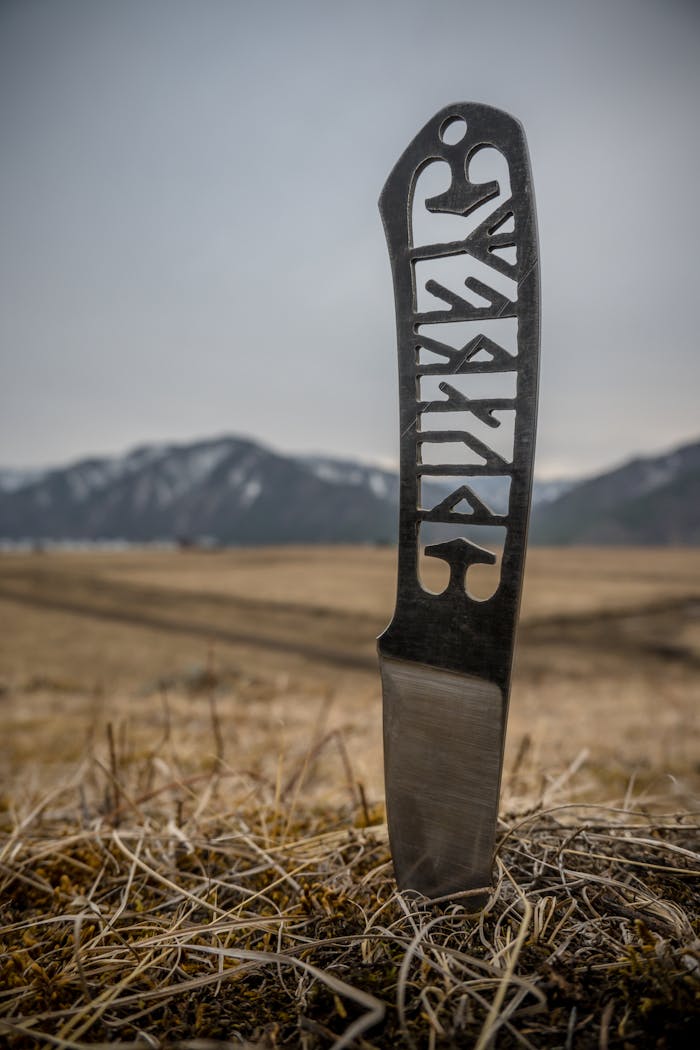Close-up of a carved steel knife in the rural landscape of Altai Republic, Russia.